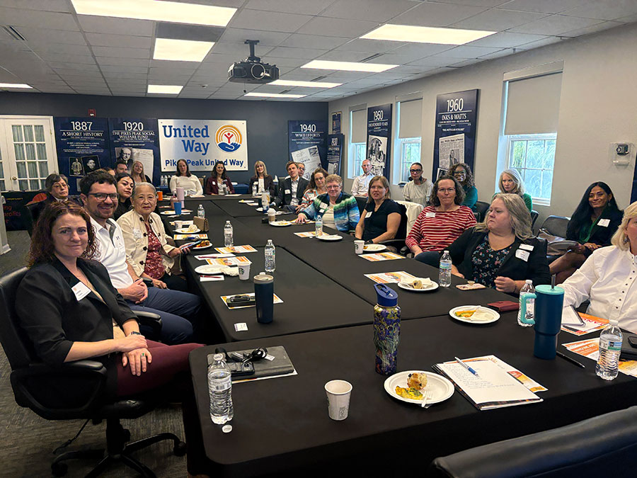 Attendees sitting at a large conference room table at a recent TANGO Alliance event hosted by Pikes Peak United Way in Colorado